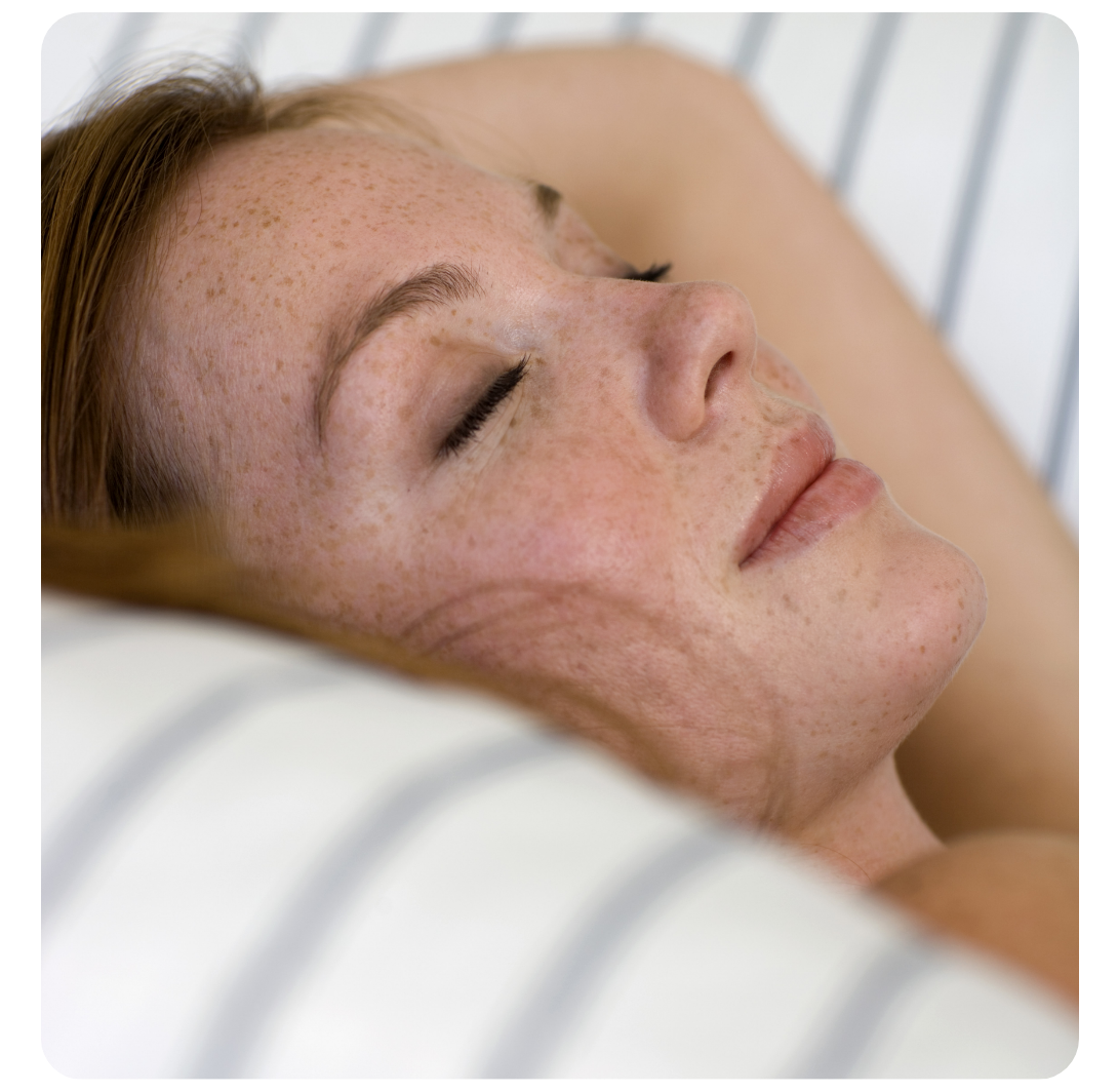 Eine Frau liegt im Bett und liest ein Buch.