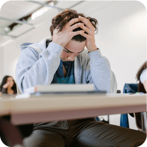 Jugendlicher sitzt frustriert im Unterricht