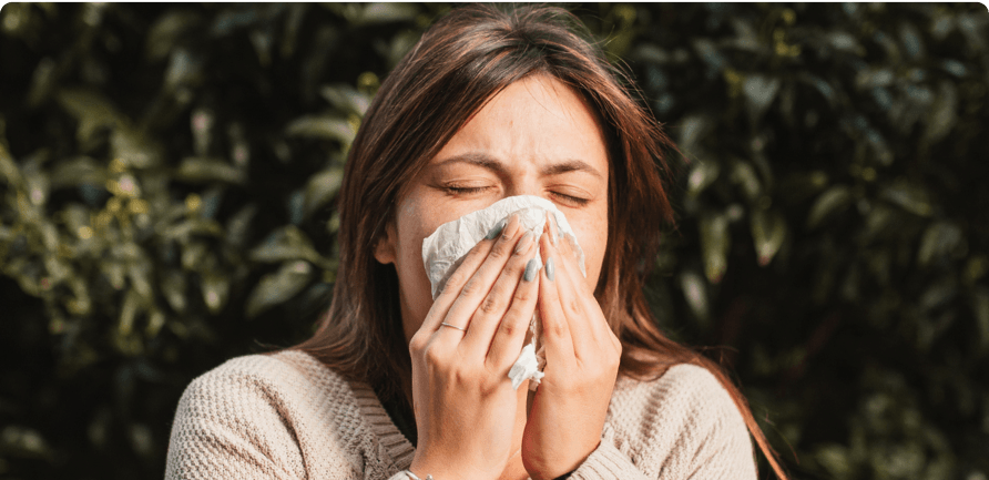 Frau niest aufgrund von Allergien