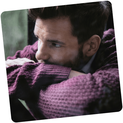 Neurodermitis-Patient sieht nachdenlich aus dem Fenster