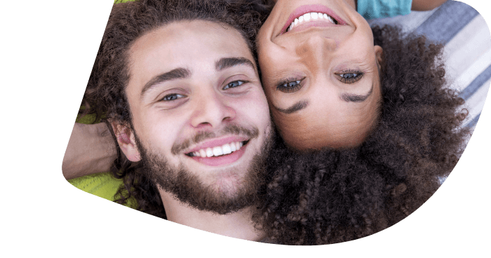 Paar liegt dicht beieinander und lächelt